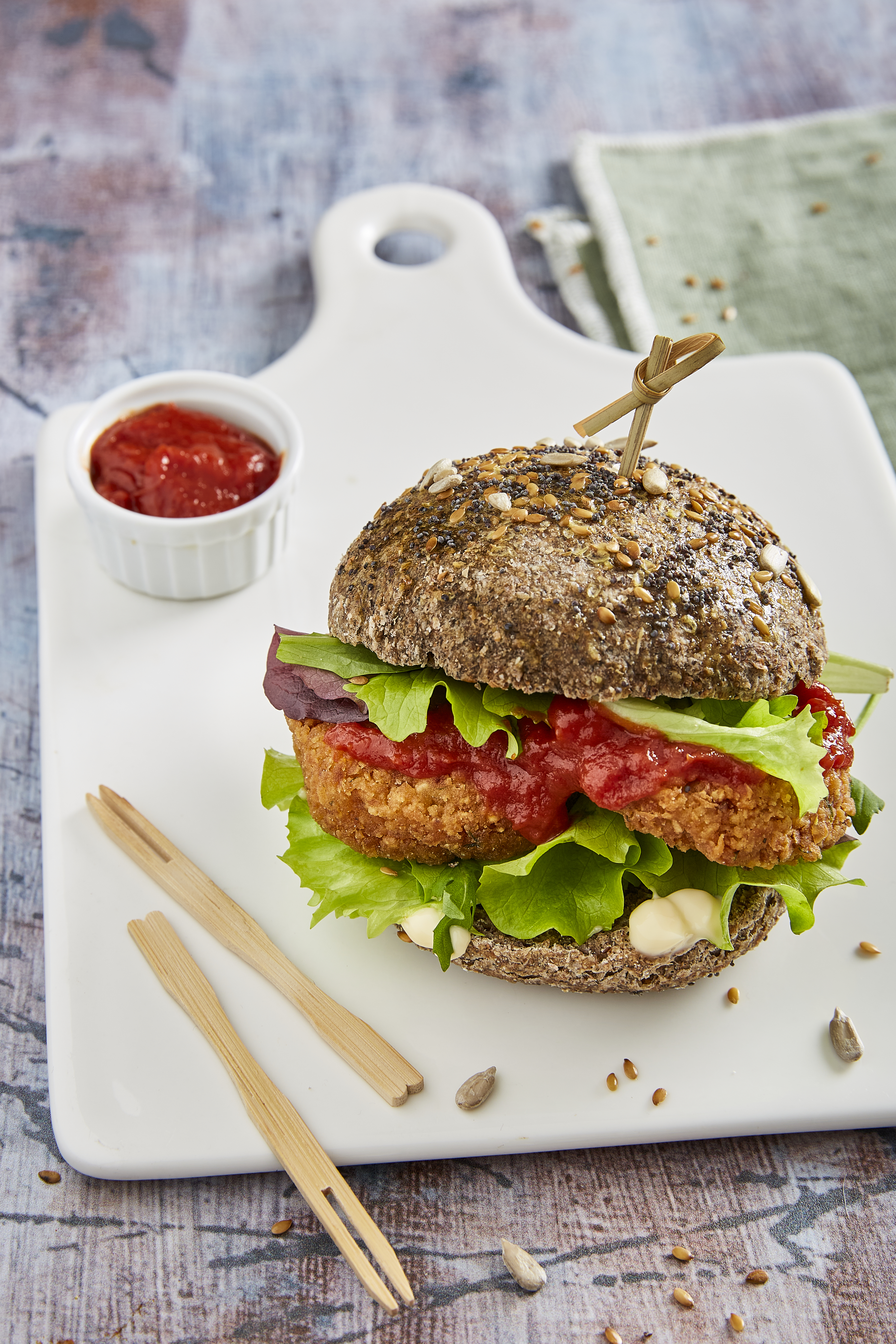 Falafel burger with salad, spicy tomato sauce and lemon tahini