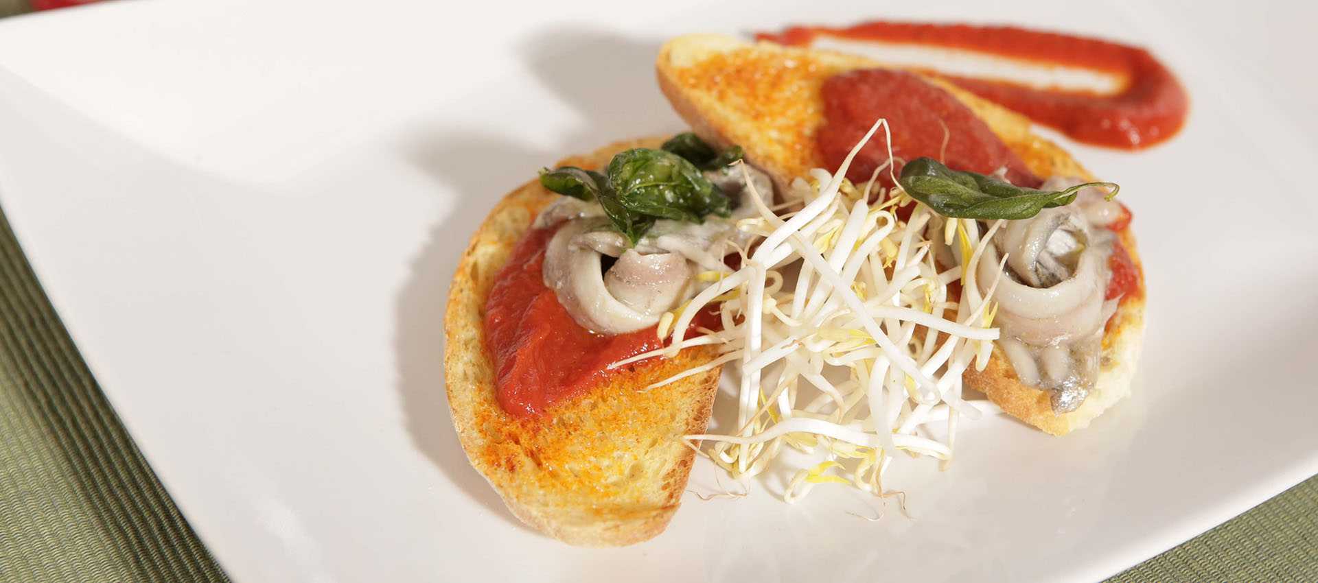 Bruschetta with marinated anchovies and fiery red sauce