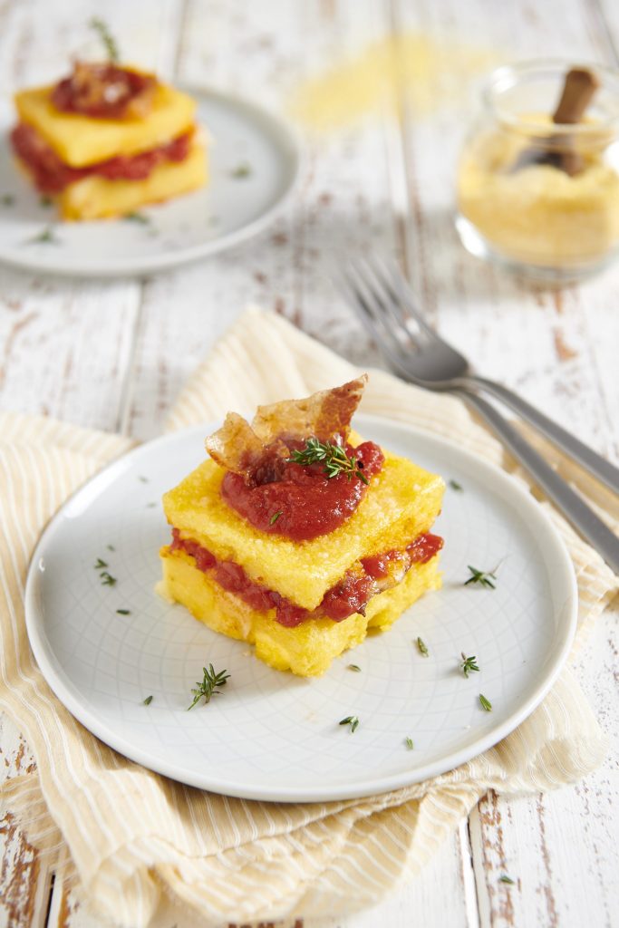 Polenta concia con formaggio, speck e salsa di pomodoro Polenta concia con formaggio, speck e salsa di pomodoro